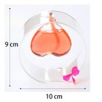 Sfera di vetro decorativa con liquido rosso e fiocco rosa, perfetta come oggetto scientifico o decorativo. Misura circa 9 cm di altezza e 10 cm di diametro, ideale per ambienti educativi o di design.