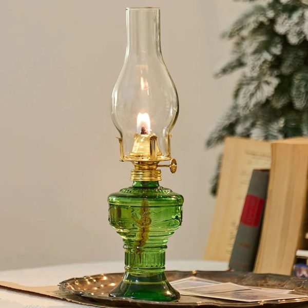 Lampada a olio vintage in vetro verde con fiamma accesa, decorativa e funzionale.
