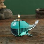 Candela a forma di pesce in vetro colorato con fiocco di raso, perfetta come decorazione scientifica o regalo originale.