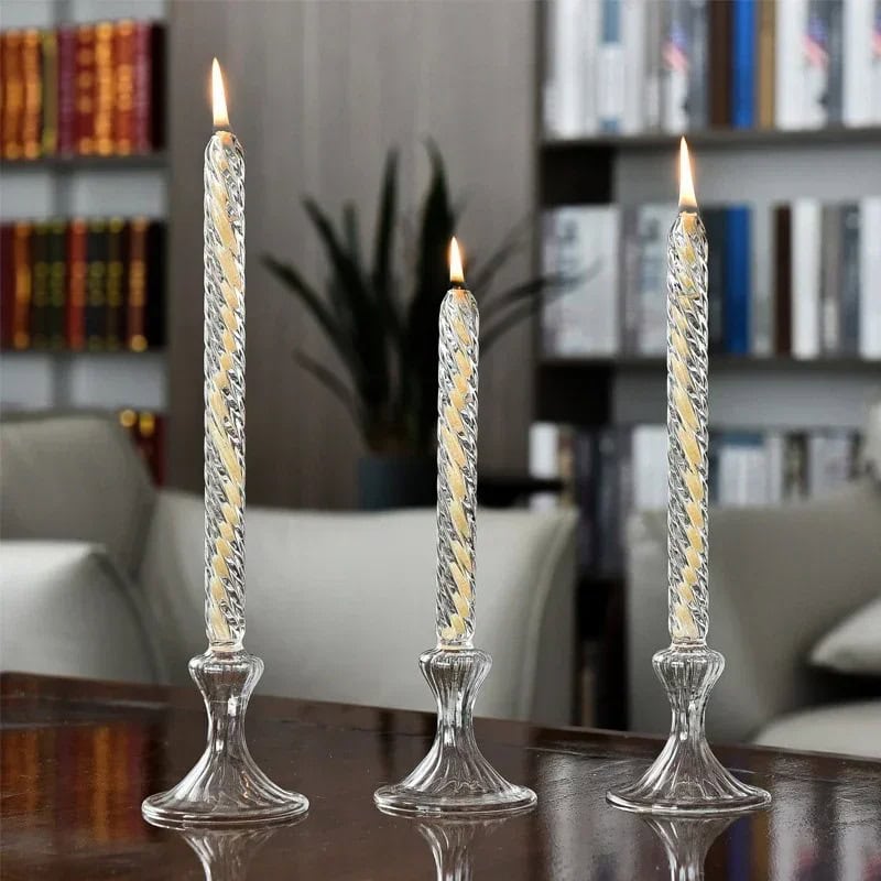 Fiamme di candela in bicchieri di vetro decorativi Tre candele accese in bicchieri di vetro decorativi, creando un'atmosfera calda e accogliente in un ambiente domestico elegante.