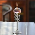 Candela in vetro con supporto scientifico decorativo, perfetta per ambienti di studio o decorazioni a tema scientifico.