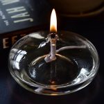 Candela decorativa con fiammella in vetro, perfetta come oggetto scientifico o decorativo per ambienti studiati e moderni.