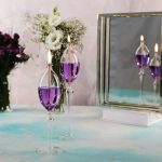Vasi decorativi con liquido viola e candele accese, perfetti come oggetti scientifici decorativi.