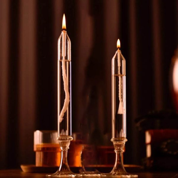 Due candele di laboratorio in vetro con fiamma accesa, ideali come decorazioni scientifiche o per esperimenti. Design elegante e trasparente, perfette per ambienti educativi o decorativi.