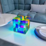 Cubo luminoso in vetro colorato con effetti di luce multicolore, ideale come decorazione scientifica o oggetto da collezione.