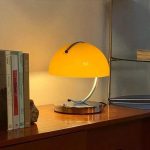 Lampada da tavolo gialla con design elegante e luce calda, ideale per ambienti domestici e uffici, aggiunge un tocco di colore e stile alla tua zona di lavoro o relax.