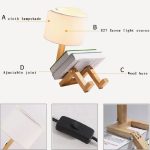 Oggetto decorativo ispirato alla scienza, con base in legno, lampada con paralume in tessuto e dettagli tecnici.