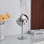 Lampada decorativa moderna in stile futuristico con finitura cromata, ideale per arredare ambienti contemporanei e aggiungere un tocco di design innovativo.