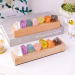 Cristalli colorati di varie forme e dimensioni su supporti di legno, ideali come decorazioni scientifiche o oggetti da collezione. Perfetti per appassionati di scienza e design.