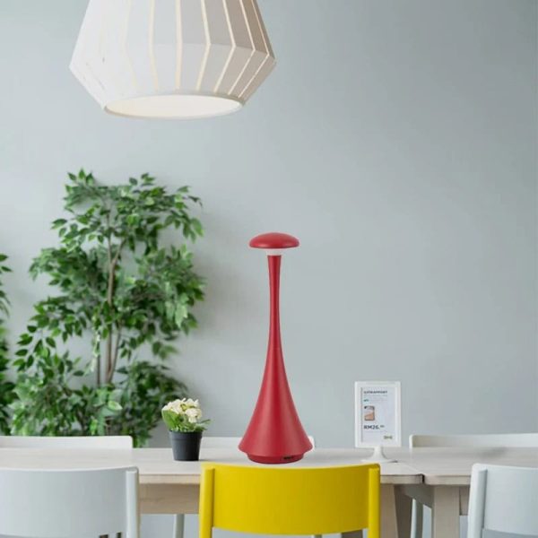 Lampada decorativa scientifica rossa in ambiente moderno con piante e sedie colorate.