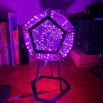 Pannello luminoso a forma di dodecaedro con luci LED viola, ideale come decorazione scientifica o oggetto di design innovativo.