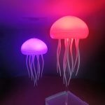 Due lampade a forma di meduse con luci LED rosa e viola, create per decorazioni scientifiche e ambienti moderni, con tentacoli ondulati e luce soffusa.