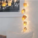 Luci decorative con pietre luminose in stile naturale, ideali per creare un'atmosfera calda e accogliente in casa o in ambienti di design.