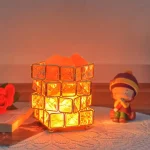 Lampada decorativa con cubi di vetro illuminati, neve artificiale e luce calda, perfetta come oggetto scientifico decorativo o per ambienti creativi e accoglienti.