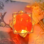 Pallina di cristallo decorativa con elementi di resina arancione, illuminata da una luce calda, ideale come oggetto decorativo scientifico o da collezione.
