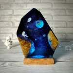 Pietra decorativa con scena spaziale, pianeta Terra, astronauta e galassie, perfetta come decorazione scientifica o oggetto da collezione.