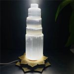 Piramide di sale rosa dell'Himalaya illuminata, oggetto decorativo e scientifico, ideale per ambienti naturali e studi scientifici, con base decorativa elegante.