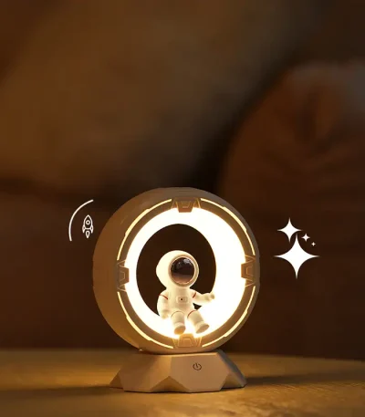 Lampada da tavolo a tema spaziale con astronauta e anello luminoso, perfetta come decorazione scientifica e oggetto di design innovativo.