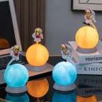 Figurine di astronauti in miniatura su sfere luminose di diversi colori, create come decorazioni scientifiche originali. Perfette per appassionati di spazio e scienza, ideali come oggetti decorativi u.