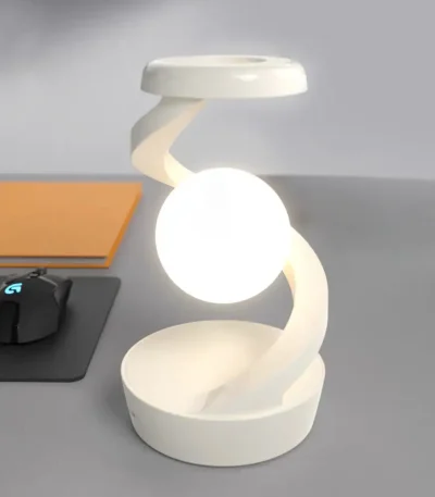 Lampada decorativa a forma di atomo con base e struttura curvata in stile scientifico.