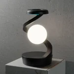 Lampada decorativa moderna con sfera luminosa e spirale nera, ideale per ambienti scientifici e di design, crea un'atmosfera innovativa e elegante.