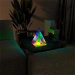 Piramide di cristallo luminosa con effetti di luce colorati, decorazione scientifica moderna per ambienti interni, ideale come oggetto decorativo e da collezione.