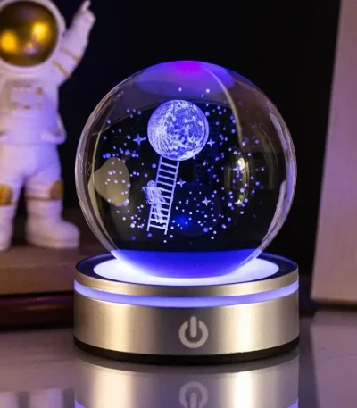 Palla di cristallo decorativa con luna, astronauta e stelle luminose, ideale come oggetto scientifico e decorativo.