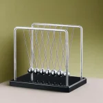 Pendolo di Newton in metallo e plastica, strumento scientifico per dimostrazioni di fisica e principi di conservazione dell'energia.