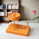 Modello decorativo scientifico in ottone e plastica arancione, perfetto come oggetto da collezione o decorazione da scrivania. Design ispirato a strumenti di laboratorio.