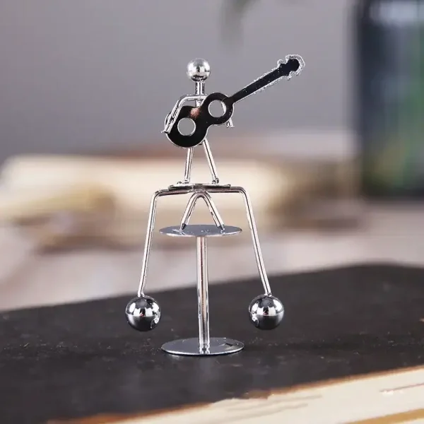 Piccolo oggetto decorativo in metallo a forma di figura umana con chitarra, ideale come decorazione scientifica o da scrivania.