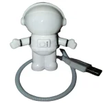 Figura di un astronauta in miniatura con casco e tuta spaziale, collegato a un cavo USB, ideale come decorazione scientifica o oggetto da collezione.