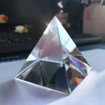 Oggetto decorativo in cristallo a forma di piramide, perfetto come decorazione scientifica o da collezione.