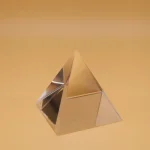 Oggetto decorativo a forma di piramide in metallo lucido, ideale per decorazioni scientifiche e ambienti moderni.