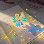 Vetrino di cristallo decorativo con riflessi iridescenti, perfetto come oggetto scientifico decorativo o da collezione, che crea effetti di luce colorata e giochi di rifrazione.