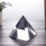 Piramide di cristallo trasparente, oggetto decorativo ispirato alla geometria sacra, ideale per arredamento scientifico e decorazioni da scrivania.