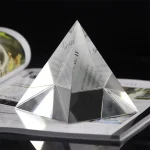 Piramide di cristallo decorativa con superfici riflettenti, ideale come oggetto di design e decorazione scientifica per ambienti moderni e studi.