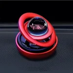 Oggetto decorativo scientifico con sfera di vetro trasparente e anelli colorati rossi e rosa, ispirato a modelli atomici, perfetto come decorazione originale e moderna.