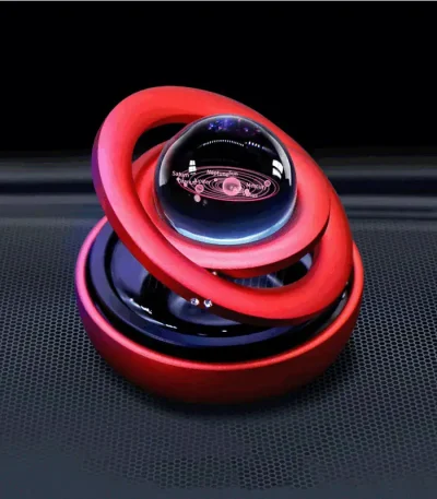Oggetto decorativo scientifico con sfera di vetro trasparente e anelli colorati rossi e rosa, ispirato a modelli atomici, perfetto come decorazione originale e moderna.