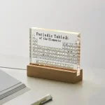 Tabella periodica degli elementi in acrilico trasparente con base in legno, decorazione scientifica elegante e moderna per appassionati di chimica e scienza.