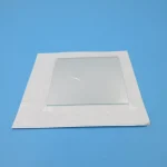 Pannello di vetro con cornice bianca, ideale come decorazione scientifica o oggetto da collezione, posizionato su sfondo azzurro.