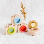 Fotocamera in legno con obiettivo colorato, giocattolo scientifico educativo.