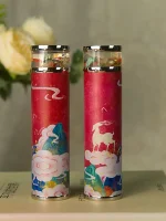 Due penne a inchiostro con decorazioni artistiche su sfondo rosa, rappresentano elementi fantastici e magici, ideali come oggetti decorativi o da collezione.