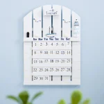 Orologio calendario decorativo con elementi scientifici, include un calendario mensile, barche e strumenti di laboratorio in stile moderno e minimalista.