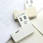Calendario perpetuo con date e mesi in più lingue, ideale come decorazione scientifica e oggetto di design per appassionati di scienza e cultura.