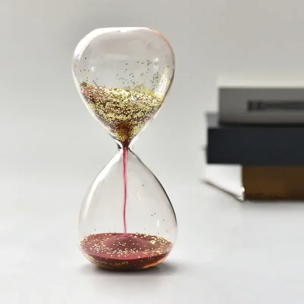 Orologio a clessidra decorativa con glitter dorato, simbolo di tempo e eleganza, perfetto come oggetto di arredamento scientifico e decorativo.