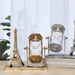 Decorazione a forma di Torre Eiffel con clessidra e oggetti scientifici, perfetta come decorazione da scrivania o da parete, ispirata ai simboli della scienza e dell'arte.