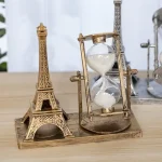 Miniatura della Torre Eiffel in metallo con clessidra decorativa, perfetta come oggetto di decorazione scientifica o da scrivania.