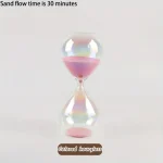 Ampolla di vetro colorata con sabbia rosa che scorre lentamente.