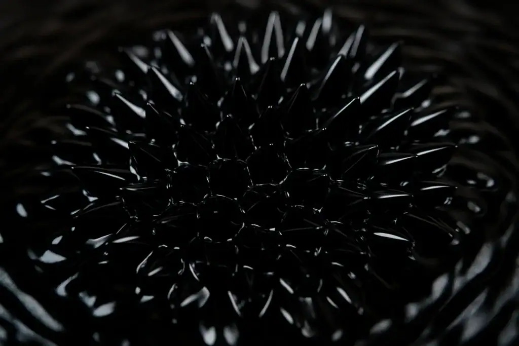 Immagine di palline di vetro nere con punte appuntite, disposte in modo concentrico, creando un effetto visivo interessante e decorativo.