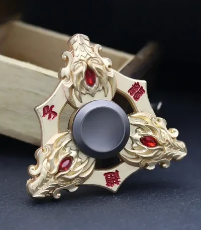 Fidget spinner a forma di drago con dettagli dorati e pietre rosse, perfetto come decorazione scientifica o oggetto da collezione.